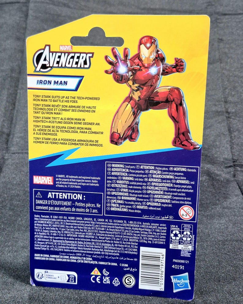 Puede incluir: Una tarjeta de embalaje de figura de acci&oacute;n de Marvel Avengers Iron Man con un fondo amarillo y azul y un gr&aacute;fico de Iron Man en cuclillas. La tarjeta incluye el logotipo de Marvel Avengers, texto del producto, advertencias y un c&oacute;digo de barras.