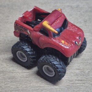 A red toy monster truck with black tires and white rims. The truck has yellow horns and a bull-like design on the front. The text "Toro Loco" is visible on the side.