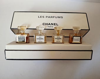 Chanel, una caja de regalo con el nombre y la marca que contiene 4 extractos de perfume en miniatura: Allure, Coco Mademoiselle, Number 5 y Number 19.