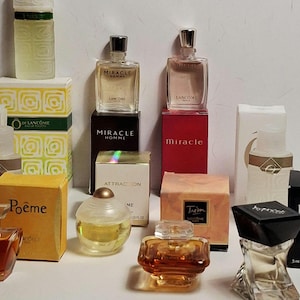 Puede incluir: Colección de frascos de perfume en miniatura, incluyendo Miracle, Miracle Homme e Hypnôse de Lancôme. Los frascos varían en forma y color, algunos se muestran en sus cajas originales. La imagen muestra una variedad de fragancias.