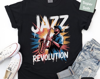 May include: Black t-shirt with a graphic of a musician playing a saxophone, with the words "JAZZ REVOLUTION" in white. The design features a colorful burst of red, orange, blue, and yellow. White sneakers and blue jeans are also visible.
