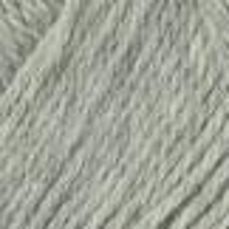 May include: Close-up of a skein of pale grey yarn. The yarn is tightly wound and has a slightly textured appearance. The colour is a muted, neutral tone, suitable for various knitting and crochet projects. The yarn appears soft and fluffy.