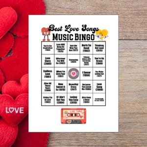 May include: A white sheet of paper with a "Best Love Songs Music Bingo" game. The bingo card features song titles and years, with a retro cassette tape graphic at the bottom. Red heart decorations are in the background.