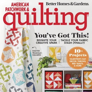 Könnte beinhalten: Ein Magazincover für "American Patchwork & Quilting" mit dem Titel "You've Got This!" und einem bunten Quilt auf der Vorderseite. Das Magazincover zeigt auch ein weißes Bücherregal mit bunten Stoffaufbewahrungsboxen.