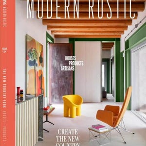 May include: The cover of Country Living magazine, titled "Modern Rustic," displays interior design. It features a yellow chair, an orange chair, and a small table with books. The text "Create the New Country Look" is also visible on the cover.