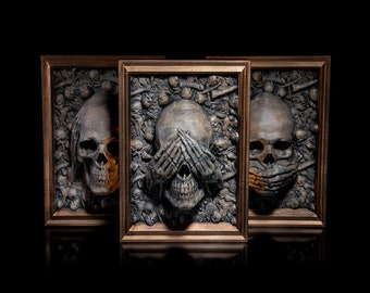 May include: Three framed skull sculptures, each with a different gesture: one with its mouth covered, one with its eyes covered, and one with its ears covered. The sculptures are made of a dark, textured material and are set against a black background.