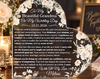 Puede incluir: Una placa de acrílico transparente en forma de corazón con un borde floral de rosas blancas y crema. El texto dice: To My Beautiful Grandma On My Wedding Day 10.21.2026, seguido de un mensaje de gratitud y amor, firmado por Melissa.