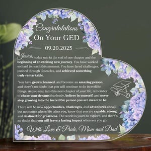 Op de afbeelding: Hartvormige acrylplaat met bloemaccenten en de tekst "Congratulations On Your GED 09.20.2025". De plaat bevat een persoonlijke boodschap en is een afstudeercadeau.