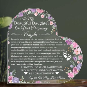 May include: A heart-shaped acrylic plaque with a floral design and the text "To My Beautiful Daughter On Your Pregnancy Angela" and "I LOVE YOU SO MUCH, I AM BEYOND PROUD OF YOU AND I CAN'T WAIT TO BE A GRANDMOTHER! With All My Love, Mom".