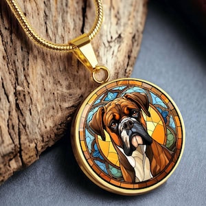 May include: A gold chain necklace with a round pendant featuring a stained glass design of a brown and white boxer dog. The pendant has a blue, yellow, and orange stained glass design.