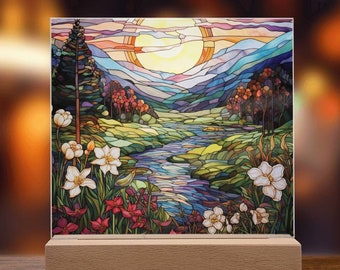 May include: A stained glass style artwork depicting a colourful landscape with a river winding through a valley. The scene features a bright yellow sun, green hills, blue mountains, and white flowers.