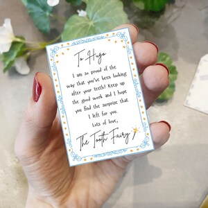 May include: A blue and white card with gold stars around the border. The card has a message for "Haga" from the Tooth Fairy. The message says, "I am so proud of the way that you've been looking after your teeth! Keep up the good work and I hope you find the surprise that I left for you. Lots of love, The Tooth Fairy."