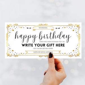 May include: A rectangular white gift voucher with a gold decorative border, black polka dots, and small gold hearts. The text reads: TO DANIEL, happy birthday, THIS VOUCHER ENTITLES YOU TO WRITE YOUR GIFT HERE, ANY EXTRA DETAILS HERE, LOTS OF LOVE, LIZZIE X.