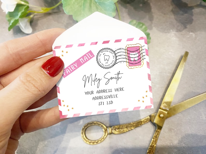 May include: A pink and white envelope with gold stars and the words "Fairy Mail" printed on it. The envelope is addressed to "Miley Smith" with an address and postcode. The envelope has a pink stamp with a tooth on it.