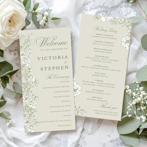 Könnte beinhalten: Zwei Hochzeitszeremonieprogramme mit floralen Bordüren. Die Programme sind hellbeige mit eleganter Schrift und den Namen "Victoria & Stephen". Ein Programm listet die Hochzeitsgesellschaft und das andere die Zeremonienreihenfolge auf.