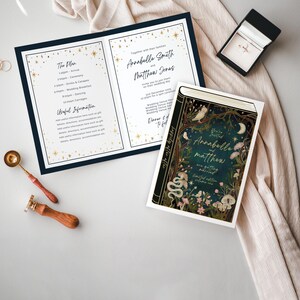 May include: A wedding invitation with a dark blue and gold design. The invitation features a book cover with a forest scene and the text "You're Invited Annabella and Matthew are getting married".