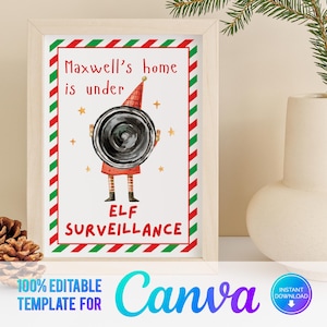 以下が含まれることがあります： 赤と緑のストライプの縁取りが付いた印刷可能なサイン。サインには「Maxwell's home is under ELF SURVEILLANCE」と書かれています。サインの中央には、黒い監視カメラを持ったエルフのイラストがあります。