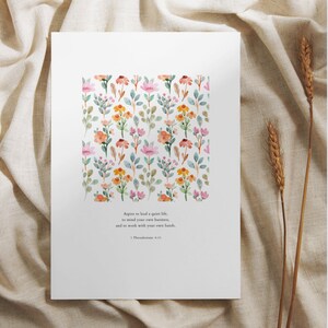 May include: A white printable art print with a watercolor floral pattern and a quote from 1 Thessalonians 4:11 that reads "Aspire to lead a quiet life, to mind your own business, and to work with your own hands."
