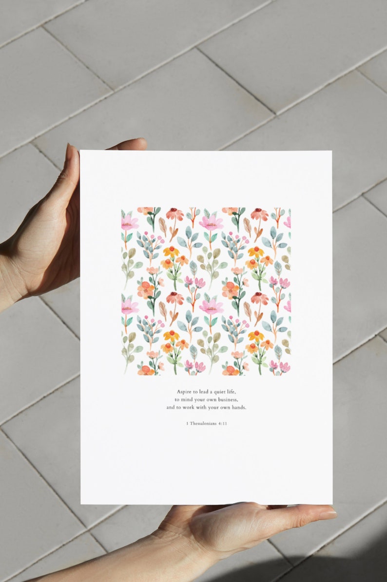 May include: A printable art print with a watercolor floral pattern and a quote from 1 Thessalonians 4:11. The quote reads: "Aspire to lead a quiet life, to mind your own business, and to work with your own hands."