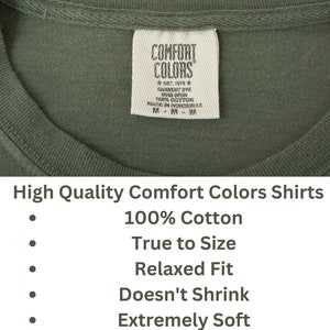 May include: A green t-shirt with a white tag that reads "Comfort Colors" and "Est. 1975" with the text "Garment Dye Ring Spun 100% Cotton Made in Honduras" on the tag. The t-shirt is described as "High Quality Comfort Colors Shirts 100% Cotton True to Size Relaxed Fit Doesn't Shrink Extremely Soft."