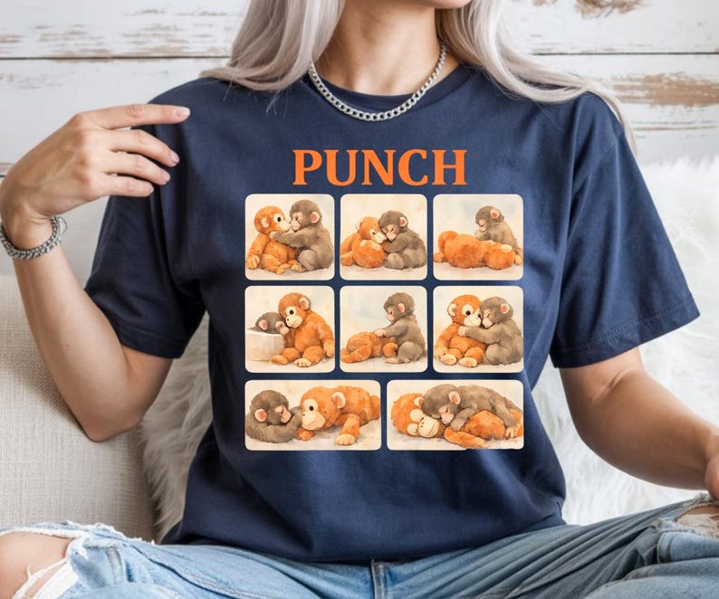 A woman wearing a blue t-shirt with a collage of images depicting various animals, including elephants, dogs, and cats.
