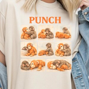A person wearing a white t-shirt with a collage of images depicting various monkey interactions, including hugging, kissing, and playing.