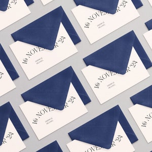 May include: A repeating pattern of cream-colored rectangular cards tucked into dark blue envelopes. Each card features the printed text 16 NOVEMBER '24 and the names SARAH & MICHAEL in a black serif font, arranged in a grid layout across the image.