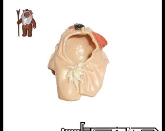 May include: A beige plastic replacement hood for a Paploo action figure, featuring a small sculpted leaf detail on the front and a dark brown accent at the top. The image includes a small reference photo of the hood on a brown figure.