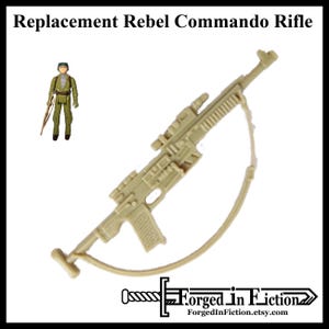 May include: A tan plastic toy rifle with a strap. The rifle has a scope and a magazine. The rifle is a replacement part for a vintage Star Wars action figure.