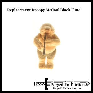 May include: A beige plastic figure of a character playing a black flute. The figure is wearing a brown loincloth. The figure is from the Star Wars franchise. The text "Replacement Droopy McCool Black Flute" is at the top of the image.