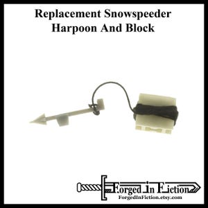 May include: Replacement harpoon and block for a Snowspeeder model. The harpoon is white plastic with a black string attached to a white plastic block.