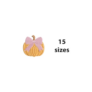 May include: Embroidered pumpkin with a pink bow and a brown stem. The pumpkin is a golden yellow color. The text "15 sizes" is displayed in black.
