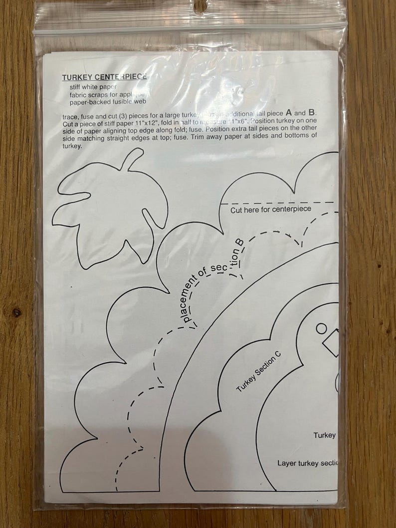 K&ouml;nnte beinhalten: Ein Schwarz-Wei&szlig;-Papiermuster f&uuml;r ein Truthahn-Bastelprojekt. Das Muster enth&auml;lt Anweisungen zum Ausschneiden und Zusammenbauen des Truthahns sowie einen Hinweis, hier f&uuml;r das Mittelst&uuml;ck zu schneiden.