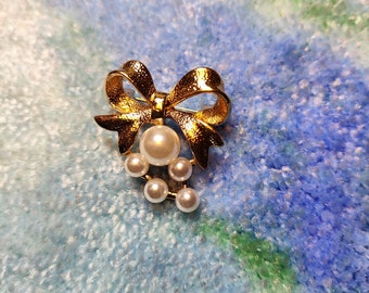 Brosche mit goldener Schleife – detailliert – glitzernd – schön – goldfarben – Schleife – Perlen