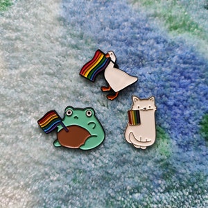 cute animal pins holding rainbow flag - goose - cat - frog - pride - LGBT - LGBTQ+