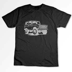 May include: A black t-shirt with a white outline of a vintage Ford Bronco.