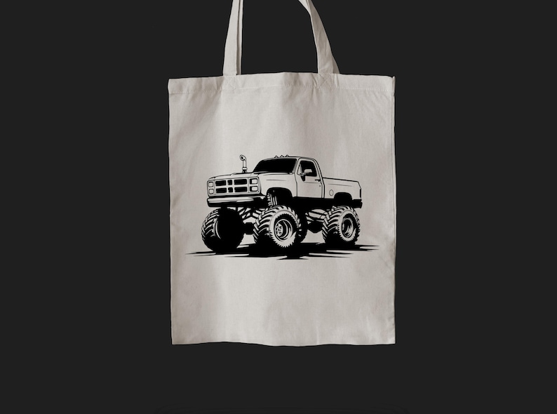 May include: A white tote bag with a black silhouette of a monster truck. The truck has large tires and a raised suspension.