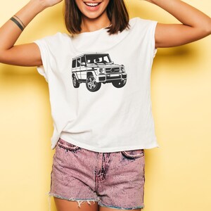 May include: A white t-shirt with a black and white illustration of a four-door SUV.