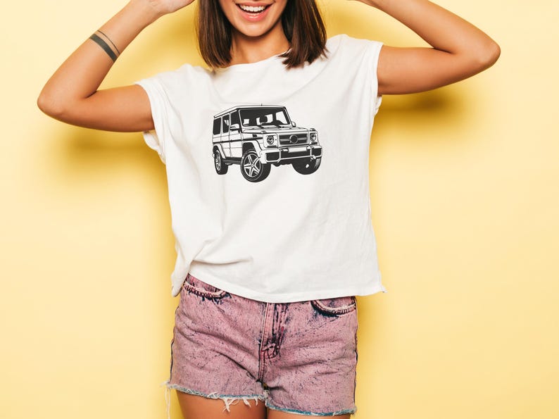 May include: A white t-shirt with a black and white illustration of a four-door SUV.