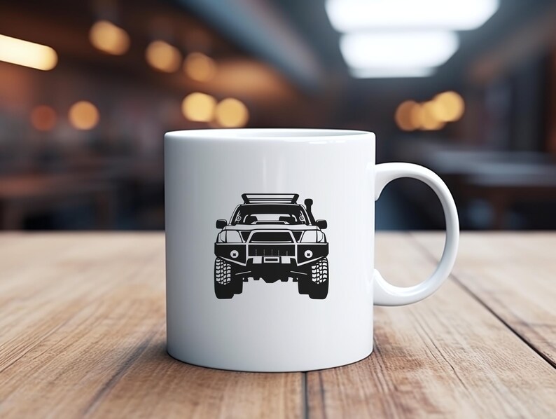 May include: White ceramic mug with a black silhouette of a 4x4 vehicle with a roof rack. The vehicle is facing the viewer.