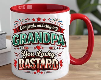 Puede incluir: Taza de cerámica blanca con interior y asa rojos. La taza presenta el texto "Congrats on being my GRANDPA You Lucky BASTARD" en un diseño colorido y juguetón con estrellas y elementos decorativos.
