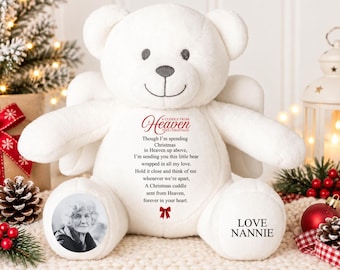 Puede incluir: Un oso de peluche blanco con alas de ángel, con el texto impreso A CUDDLE FROM HEAVEN THIS CHRISTMAS, un poema, un retrato circular en blanco y negro en el pie izquierdo y el texto LOVE NANNIE en el pie derecho.