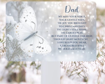 Puede incluir: Placa conmemorativa blanca con una mariposa y la palabra "Dad". El texto es un poema sobre el recuerdo. El fondo es una escena nevada.
