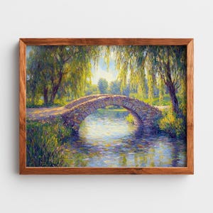 Puede incluir: Una pintura de paisaje enmarcada representa un puente de piedra que se arquea sobre un río tranquilo. Frondosos árboles y follaje verde enmarcan el puente, con la luz del sol filtrándose a través de las hojas. La obra de arte está enmarcada en madera marrón.