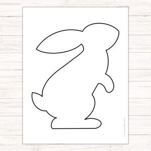 Può includere: Un contorno in bianco e nero di un coniglio in piedi sulle zampe posteriori con le orecchie dritte.