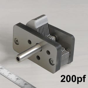 Puede incluir: Un condensador variable de color plateado con una perilla de plástico blanco. El condensador tiene una capacitancia máxima de 200pF.