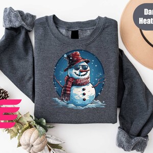 a sweater with a snowman wearing a hat and scarf