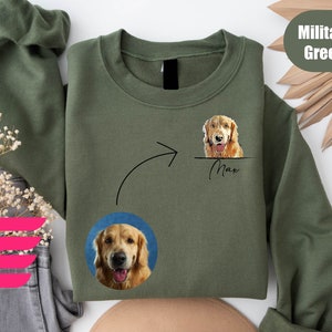 K&ouml;nnte beinhalten: Ein olivgr&uuml;nes Sweatshirt mit einem wei&szlig;en Pfeil, der auf ein Foto eines Golden Retriever-Hundes mit dem Namen "Max" darunter zeigt. Das Sweatshirt zeigt auch ein kleineres Foto des Hundes in der linken unteren Ecke.