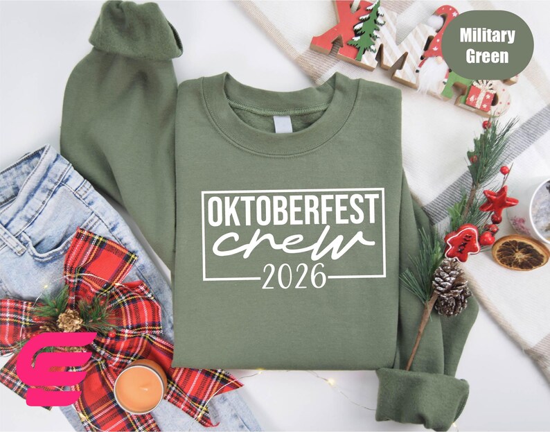 a green sweatshirt with the text "OKTOBERFEST CREW 2026" printed on it, along with various holiday-themed items such as a Christmas tree, ornaments, and a red bow.