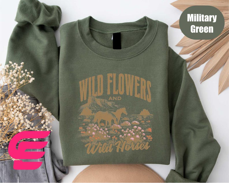 a green sweatshirt with wild flowers and wild horses on it